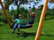 Zwei Kinder spielen auf einer großen Schaukel