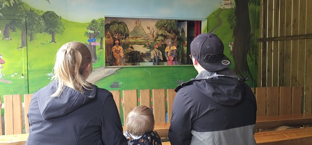 Zuschauer schauen sich die Show "Kasperle Theater" an